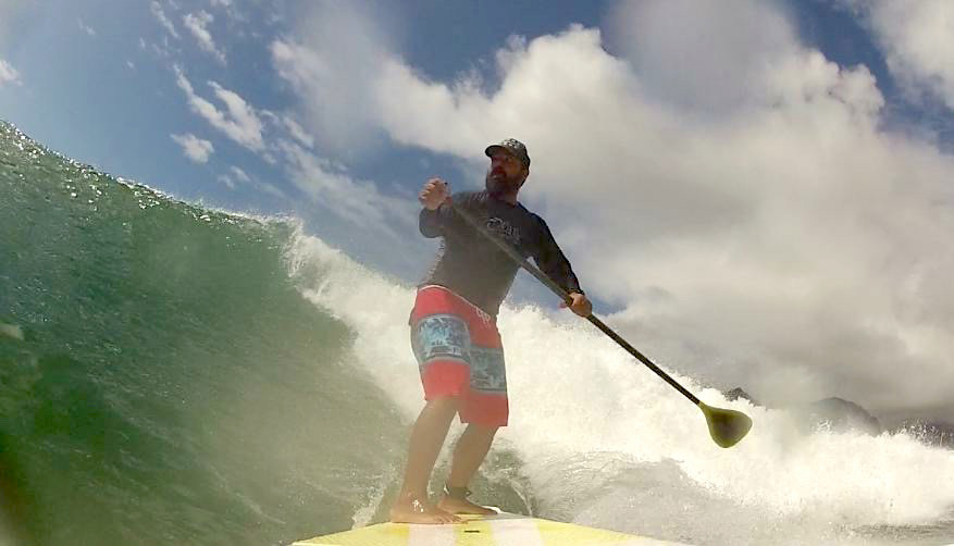 photo - CMC graduate Mark Arriola surfing a stand up paddleboard.